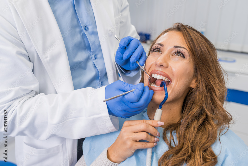 Professional handsome dentist examining teeth Professional handsome dentist examining teeth