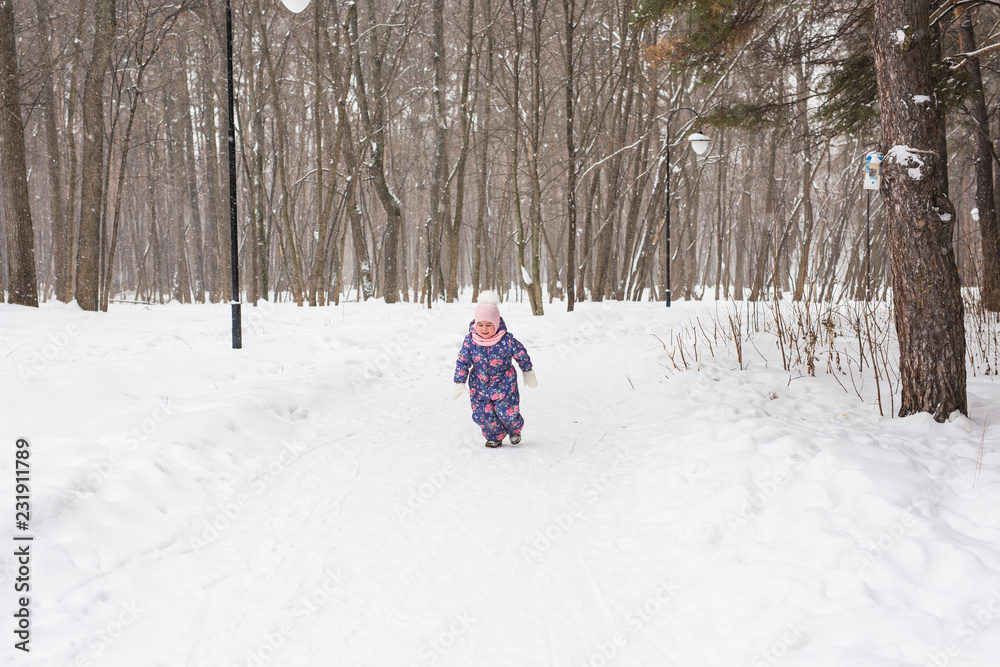 Children and nature concept - Adorable baby girl walking in winter park