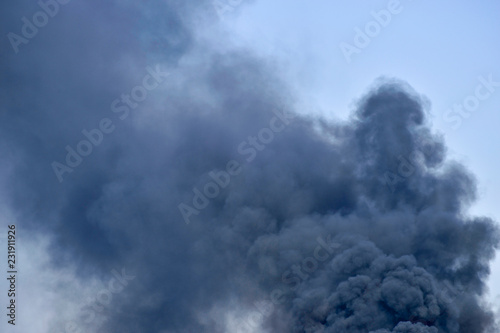 Powerful clouds of black smoke against the sky. Background. The problem of waste disposal