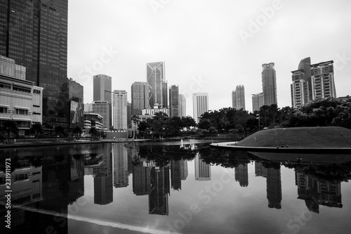 black and white image of building at Kuala Lumpur with reflection. soft focus blur due long exposure. visible noise due to High ISO.