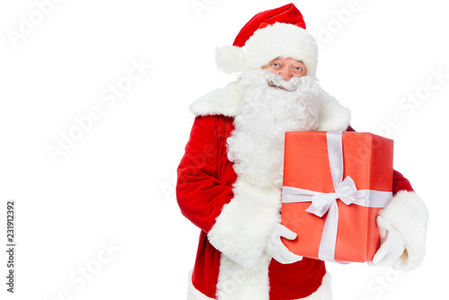 happy santa claus holding red christmas gift isolated on white