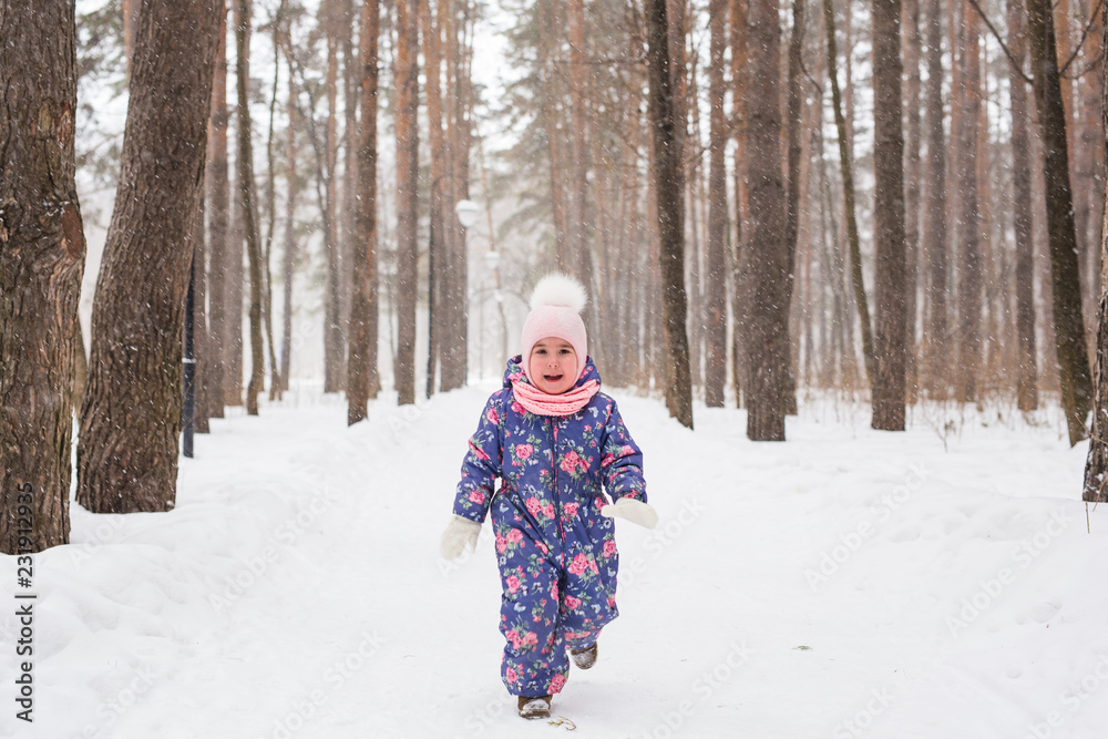 Childhood and children concept - baby girl walk in the winter outdoors
