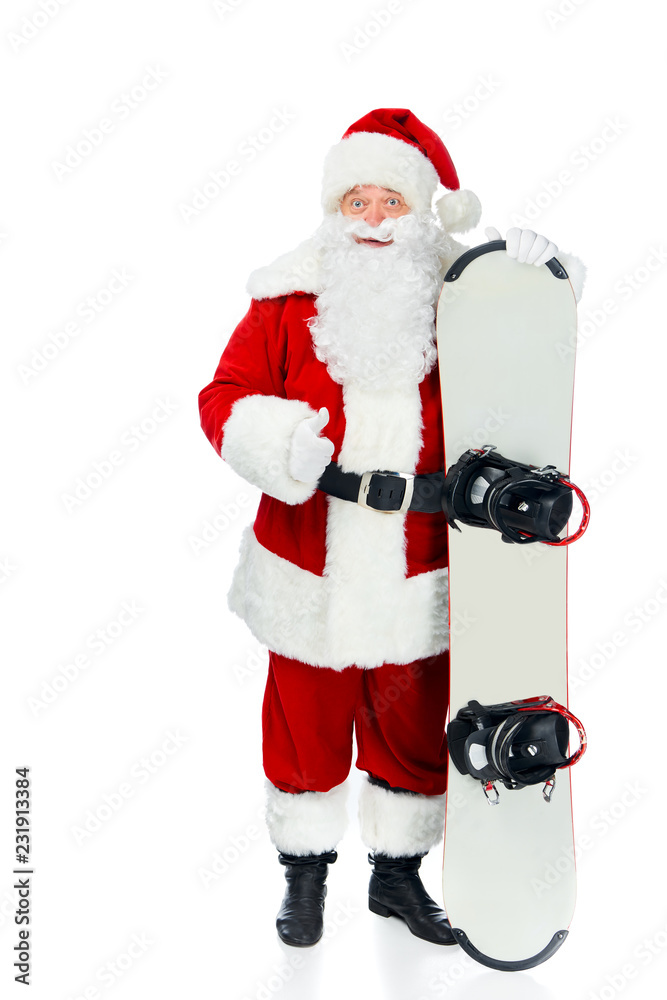 Naklejka premium Santa claus with snowboard showing thumb up isolated on white