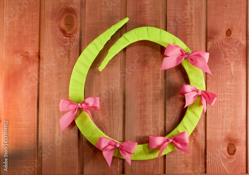 English green letter O made of plywood with a bow laid out on a wooden background