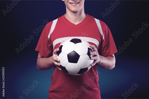 Soccer player is holding ball on background