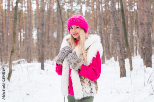 Nature, fashion and people concept - Young attractive blond woman posing in the winter park.
