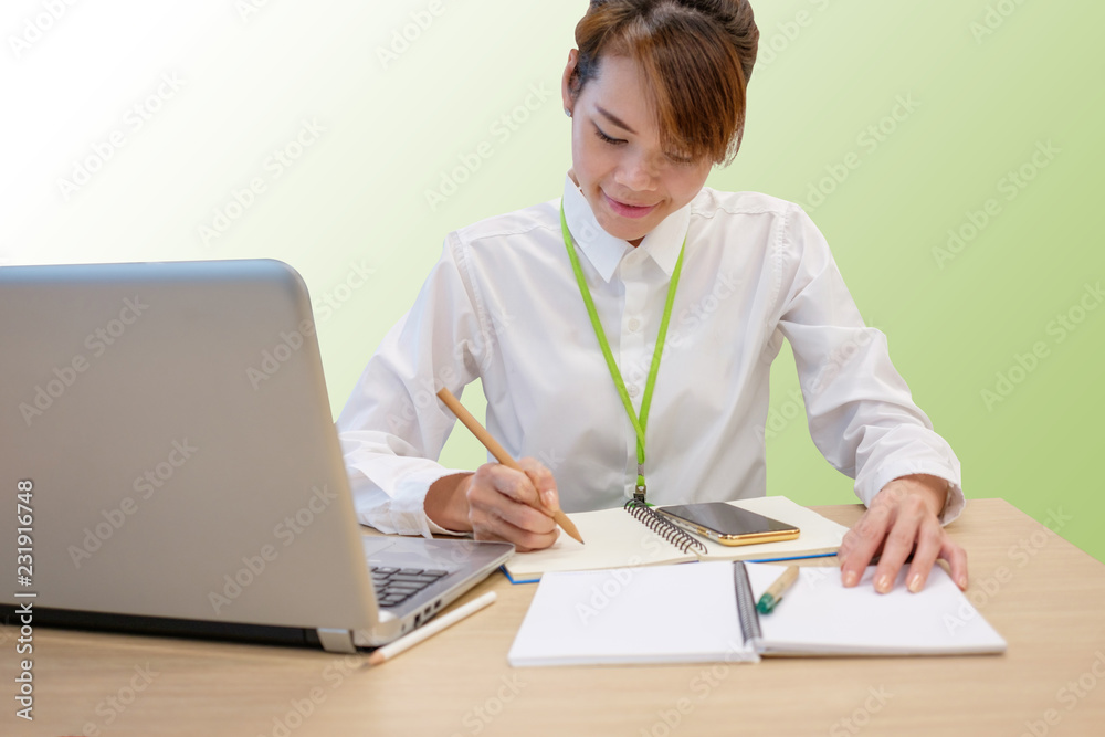 Portrait of happy asian business woman writing note book and using laptop computer while working with blank copyspace for text,isolated on clean background with clipping path. Portrait of happy asian business woman writing note book and using laptop computer while working with blank copyspace for text,isolated on clean background with clipping path.