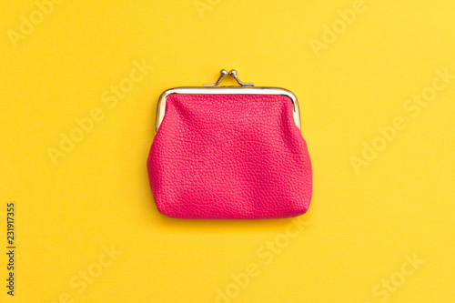 Pink wallet on yellow background . Close up. Top view
