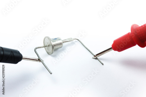 Testing diode bridge with multimeter on white background