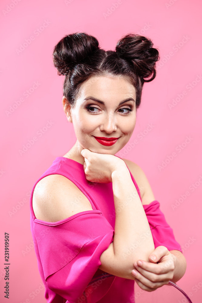 Beauty portrait of young brunette woman on a bright pink background. Model with make-up and hairstyle, closeup, fashion glamour photo Beauty portrait of young brunette woman on a bright pink background. Model with make-up and hairstyle, closeup, fashion glamour photo