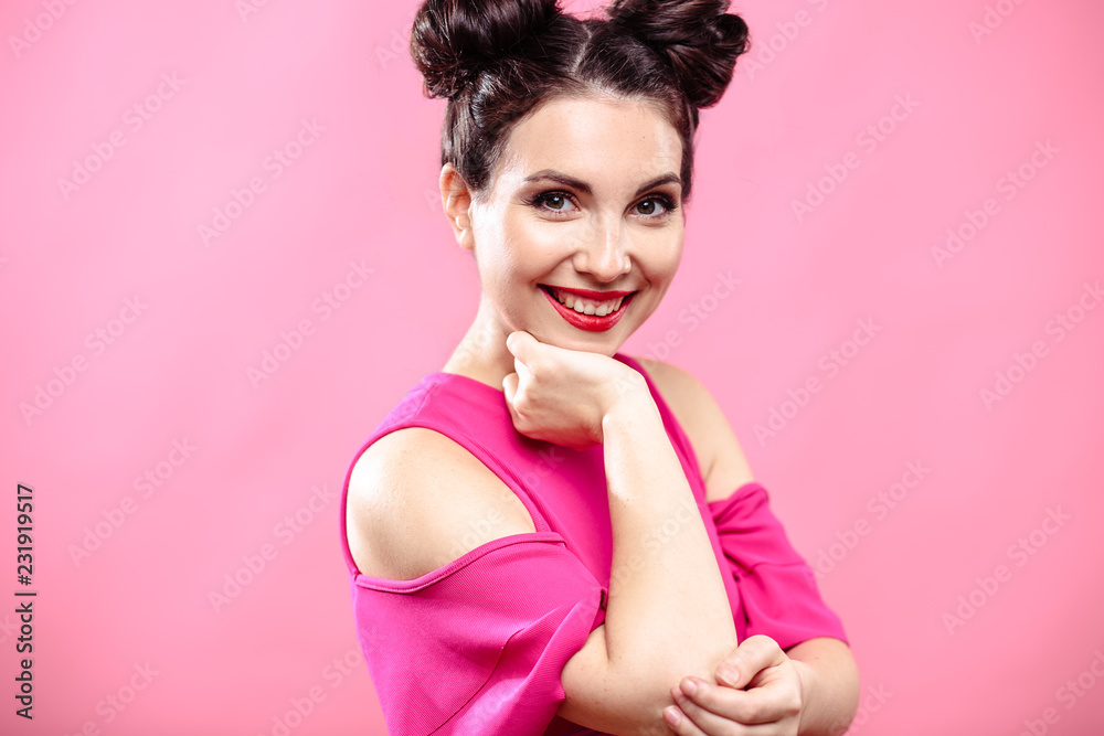Beauty portrait of young brunette woman on a bright pink background. Model with make-up and hairstyle, closeup, fashion glamour photo
