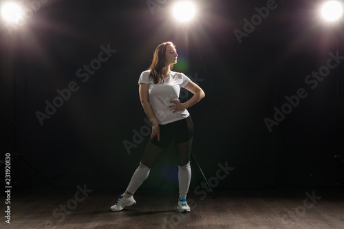 Fototapeta Naklejka Na Ścianę i Meble -  People and dance concept - Young woman dancing jazz funk over dark background