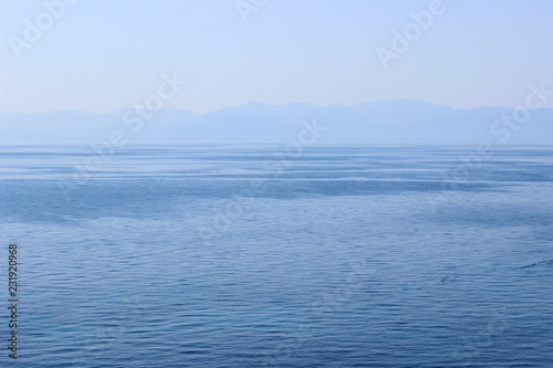 Deep blue calm sea water landscape seascape clear sky land horizon sunset