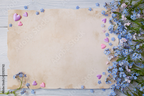 Background for congratulations with paper, forget-me-not flowers and hearts