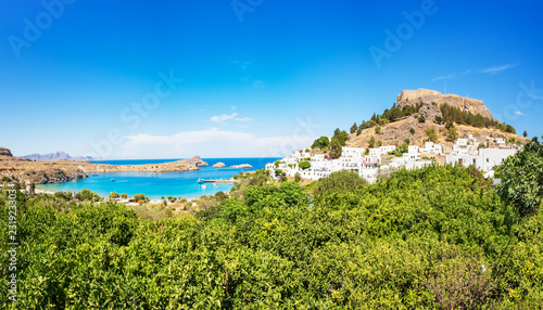 View of Acropolis of Lindos, traditional white houses and lemon trees (Rhodes, Greece)