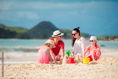 Family of four making sand castle at tropica beach