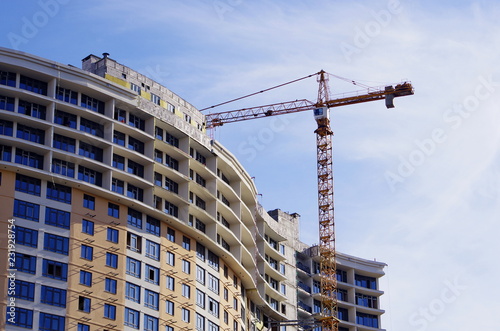  Crane and building under construction against blue sky