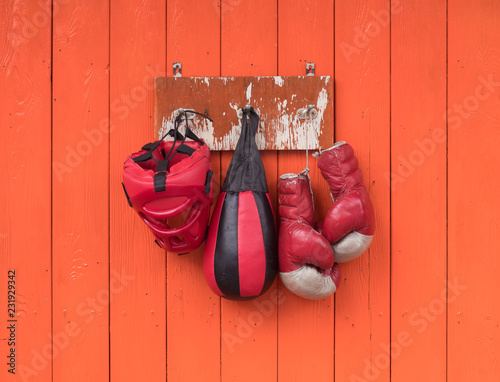 old red boxing gloves on the orange wall
