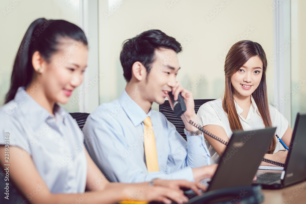 Group of businesspeople using laptop and telephone Group of businesspeople using laptop and telephone