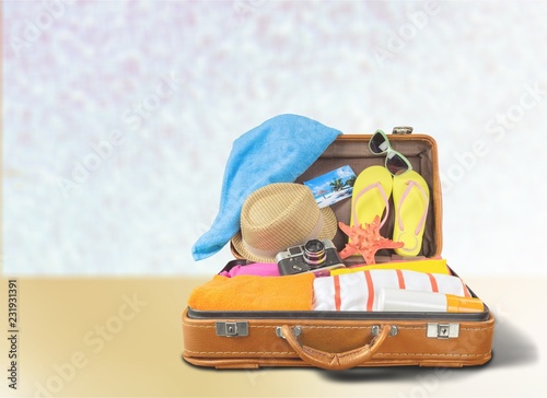 Retro suitcase with travel objects on sea background