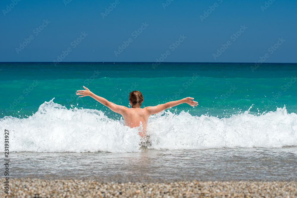 A young guy enjoys the waves and the sun on the sea beach A young guy enjoys the waves and the sun on the sea beach