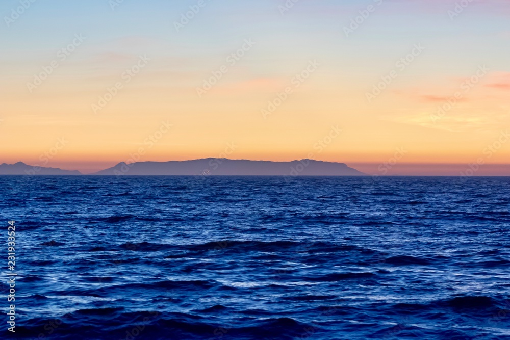 colorful sunset sky over an island and ocean colorful sunset sky over an island and ocean