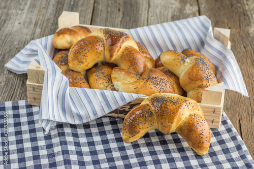 Boxes with poppy seed croissant on white-blue clothtable photo