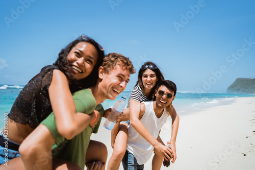 Cheerful young friends enjoying summertime on the beach