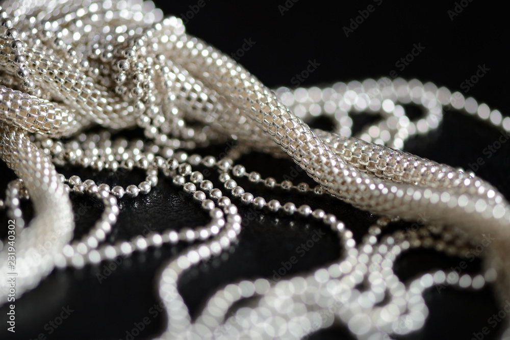Obraz premium Metal necklace tied in a knot on a dark background close up