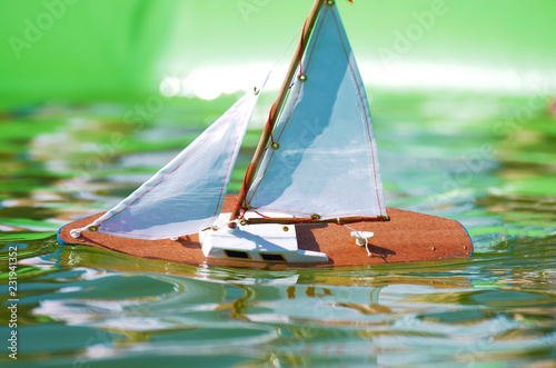 Traditional small wooden sailing boat in the pond of park