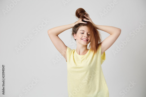 Girl in yellow t-shirt fooling around with her hair