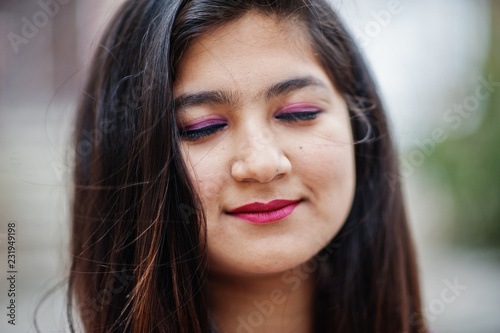 Close up portrait of indian hindu girl at traditional violet saree posed at street.