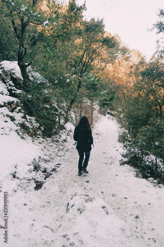 Girl walking on her back on a snowy mountain trail
