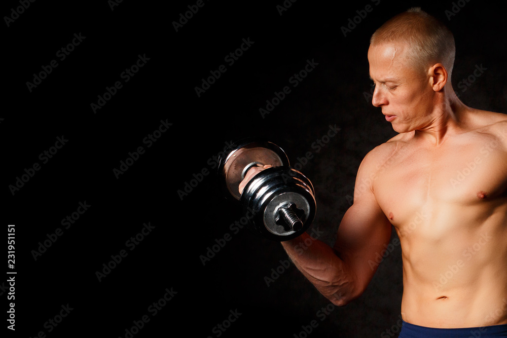 very power athletic guy , execute exercise with dumbbells, on dark background