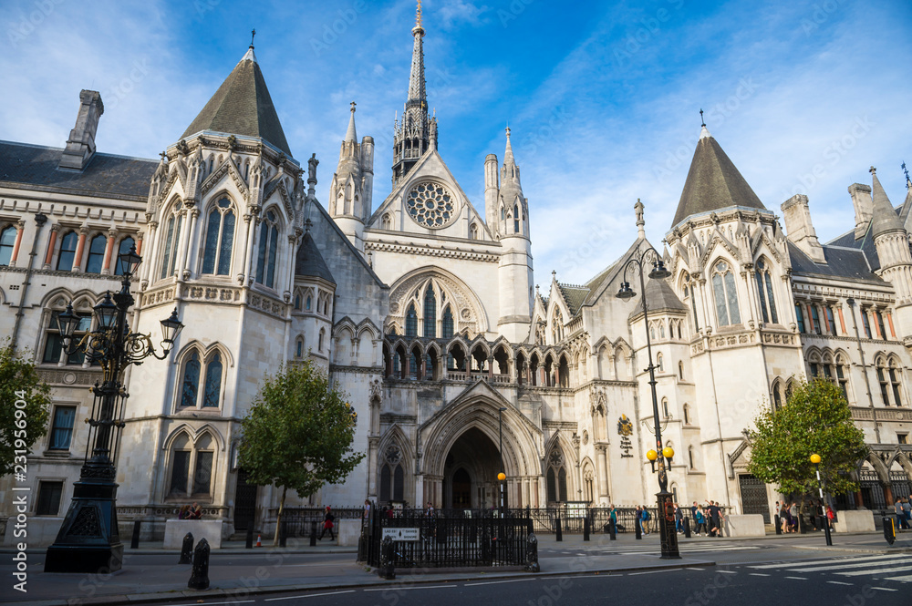 Bright afternoon view of the gothic architecture of the Royal Courts of Justice Building under blue sky in London, England, UK