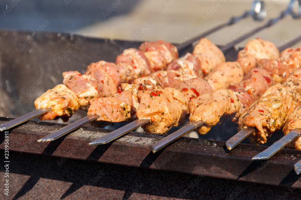 Grilled kebab cooking on metal skewer. Roasted meat cooked at barbecue