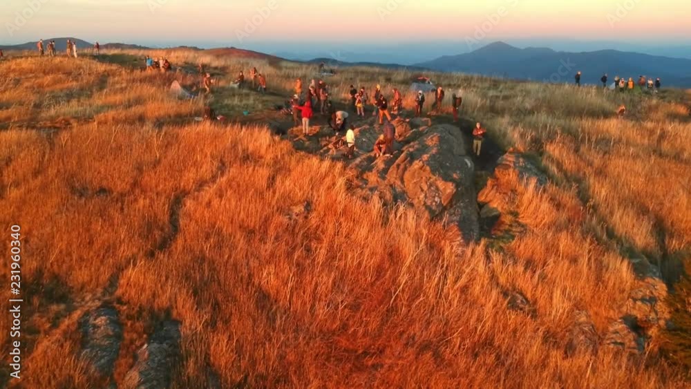 Aerial drone of group of people on mountain top in autumn in Blue Ridge Mountains near Asheville, North Carolina