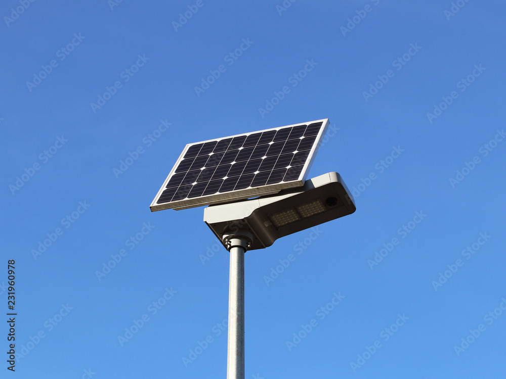 Obraz premium Solar panel on a blue sky. Photovoltaic cells. Method of obtaining alternative energy. Ecologically clean electricity. High technology of electronics. Energy independence.