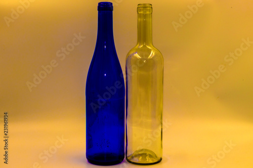 Colored empty glass bottles on white background