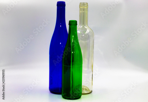 Colored empty glass bottles on white background