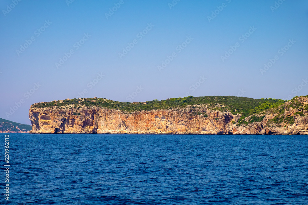 Alghero, Sardinia, Italy - Faro di Capo Caccia lighthouse at the limestone cliffs of the Capo Caccia cape at the Gulf of Alghero