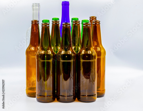 Colored empty glass bottles on white background