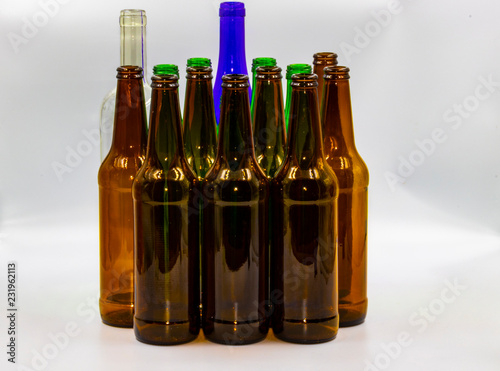 Colored empty glass bottles on white background