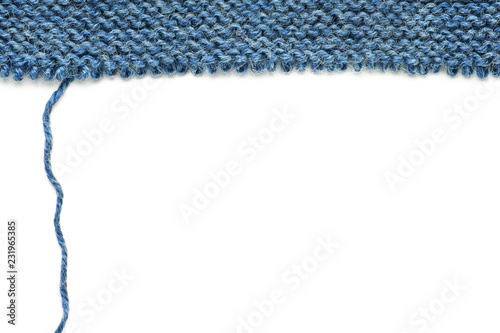 Unravelling knitted fabric on white background