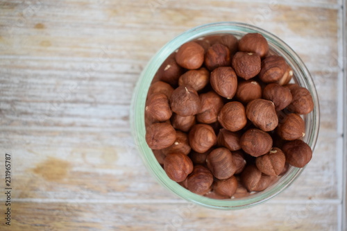 Hazelnuts in a glass jar in the background of the tree. Copy space.