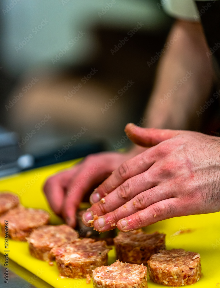 Male Chef Making Round Pork Cutlet for Some Burgers for  Wedding Meal