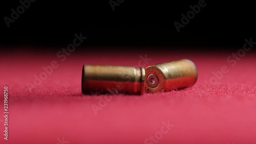 falling 9mm casings on red table top photo