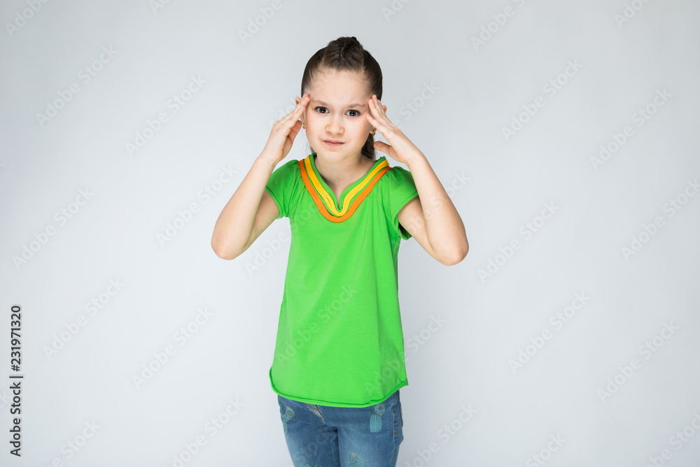 Girl on a gray background holding his fingers on his head. Girl on a gray background holding his fingers on his head.
