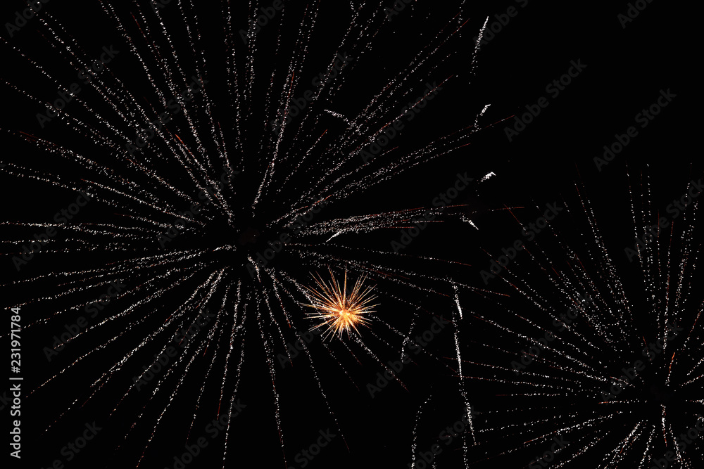 Obraz premium Fireworks in the night sky. Texture salute. Abstract photo of flares on a black background. Photos of lights salute in the sky. Image of salute flashes. Texture of colored lights.