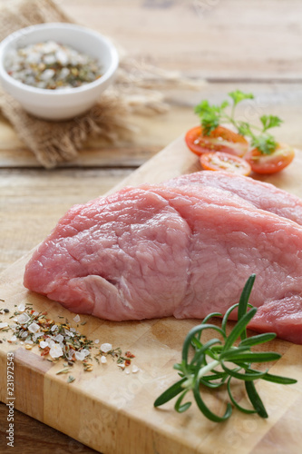 Rohe Schweineschnitzel auf einem Holzbrett